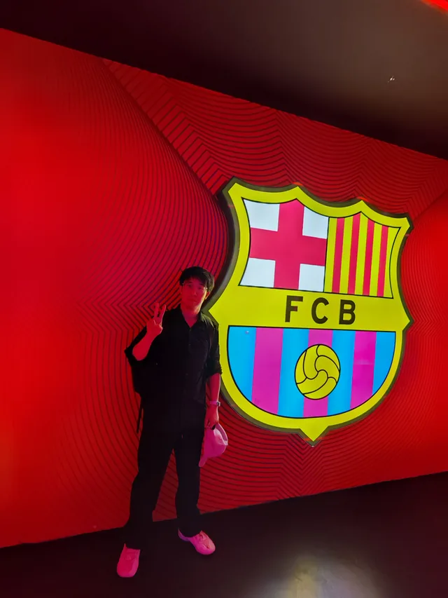 Huiyao standing beside a large FC Barcelona crest