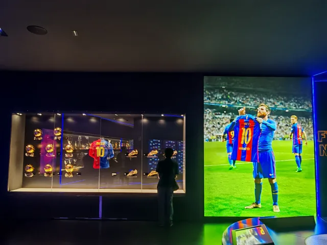Huiyao looking at Messi's trophies and shirt beside a large photograph of Messi